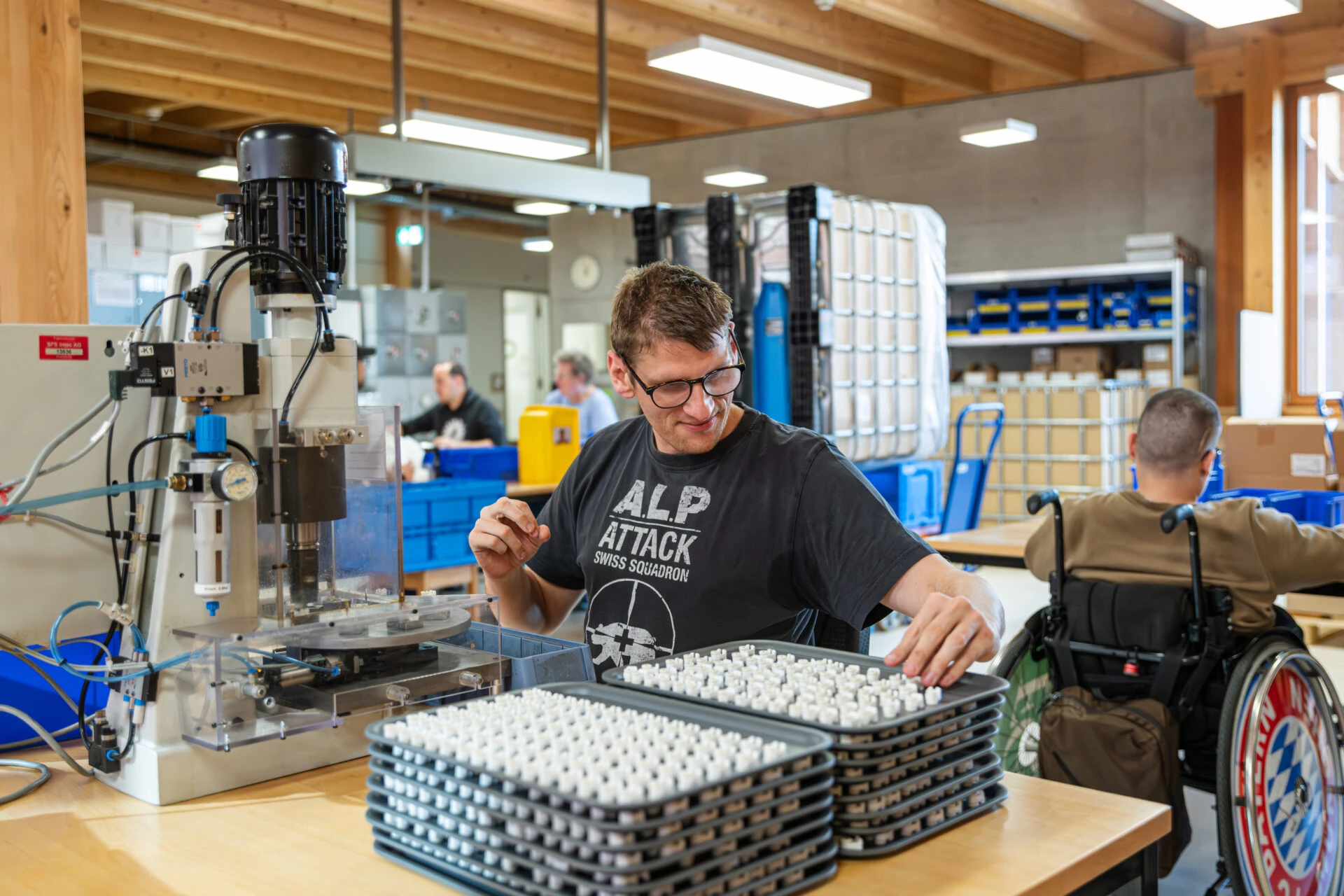 Mitarbeiter bestueckt Kleinteile an einer Montagevorrichtung in der Industriewerkstatt