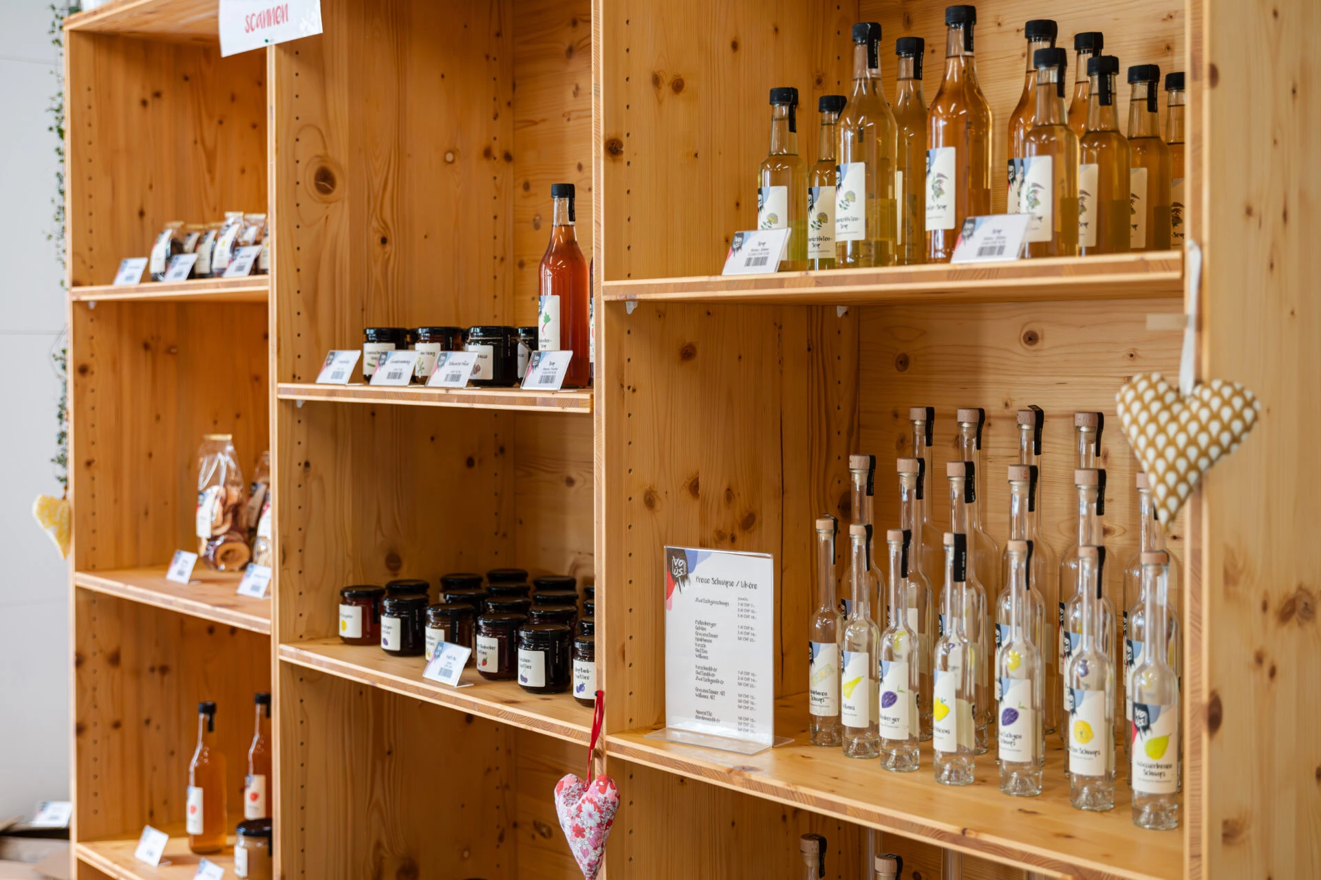 Holzregal mit hauseigenen Produkten: Konfitueren, Saefte, Sirup und Edelbraende aus Rhyboot